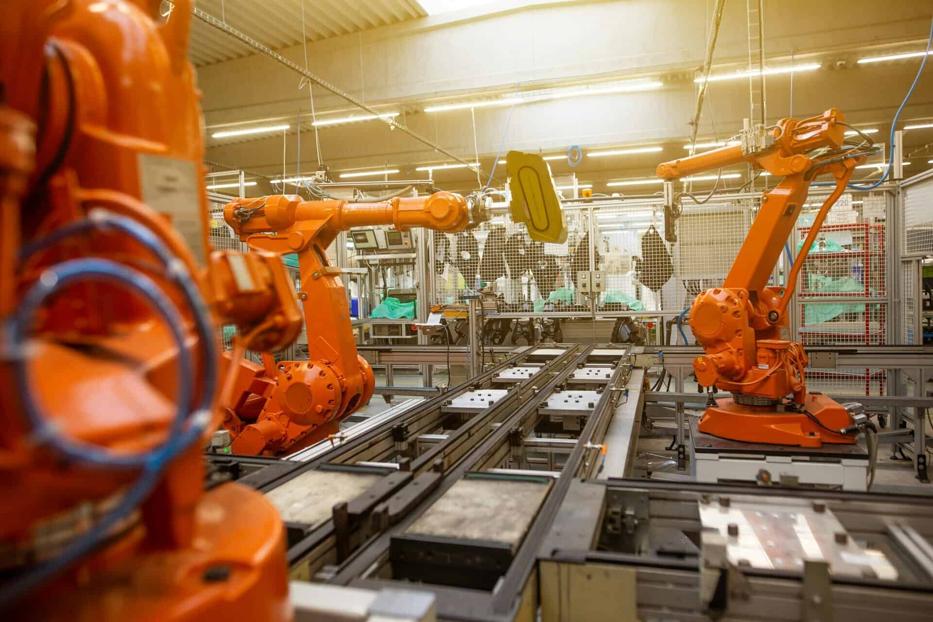 Roboterarme in einer industriellen Fertigungshalle für Oberflächenbehandlung.